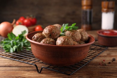 Photo of Tasty cooked meatballs with parsley on wooden table