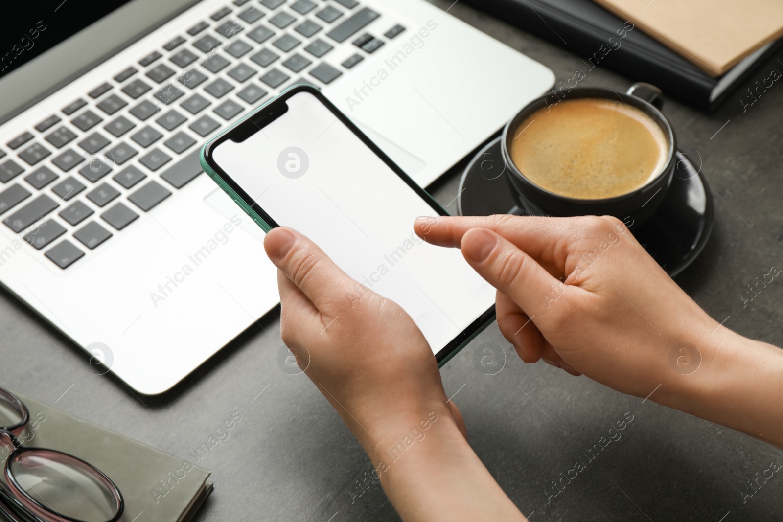 Photo of MYKOLAIV, UKRAINE - JULY 8, 2020: Woman using Iphone 11 Pro Max with blank screen at workplace, closeup