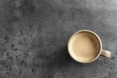 Cup of aromatic hot coffee on grey background, top view