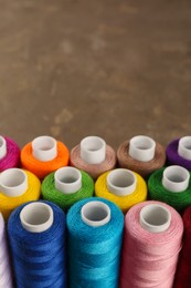 Photo of Set of color sewing threads on grey table