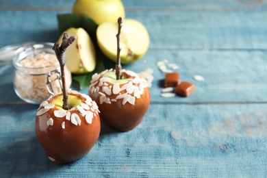 Photo of Delicious caramel apples on wooden background