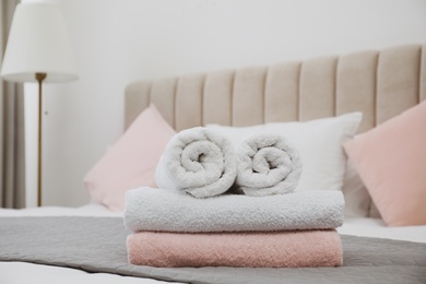 Photo of Soft clean towels on bed in room