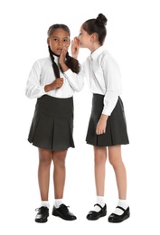 Girls in school uniform gossiping on white background