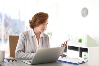 Female lawyer working with laptop at table in office