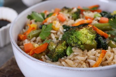 Photo of Tasty fried rice with vegetables in bowl, closeup