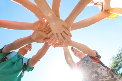 Group of children putting hands together outdoors. Summer camp