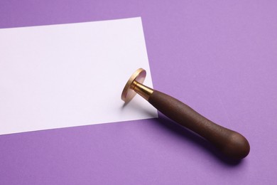 Photo of One stamp tool and sheet of paper on purple background