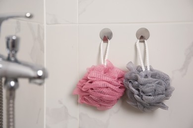 Shower puffs hanging near faucet in bathroom