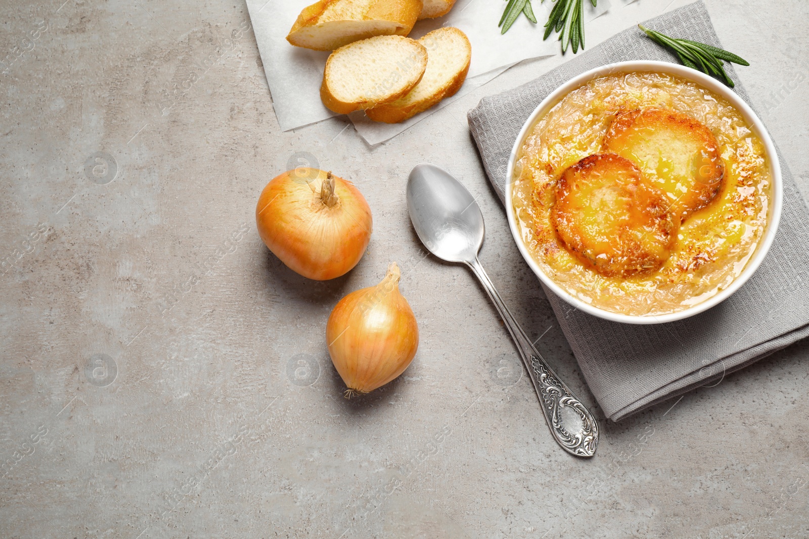 Photo of Tasty homemade french onion soup served on grey table, flat lay. Space for text