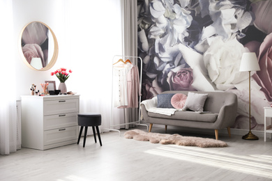 Photo of Stylish room interior with dressing table, mirror, sofa and floral wallpaper