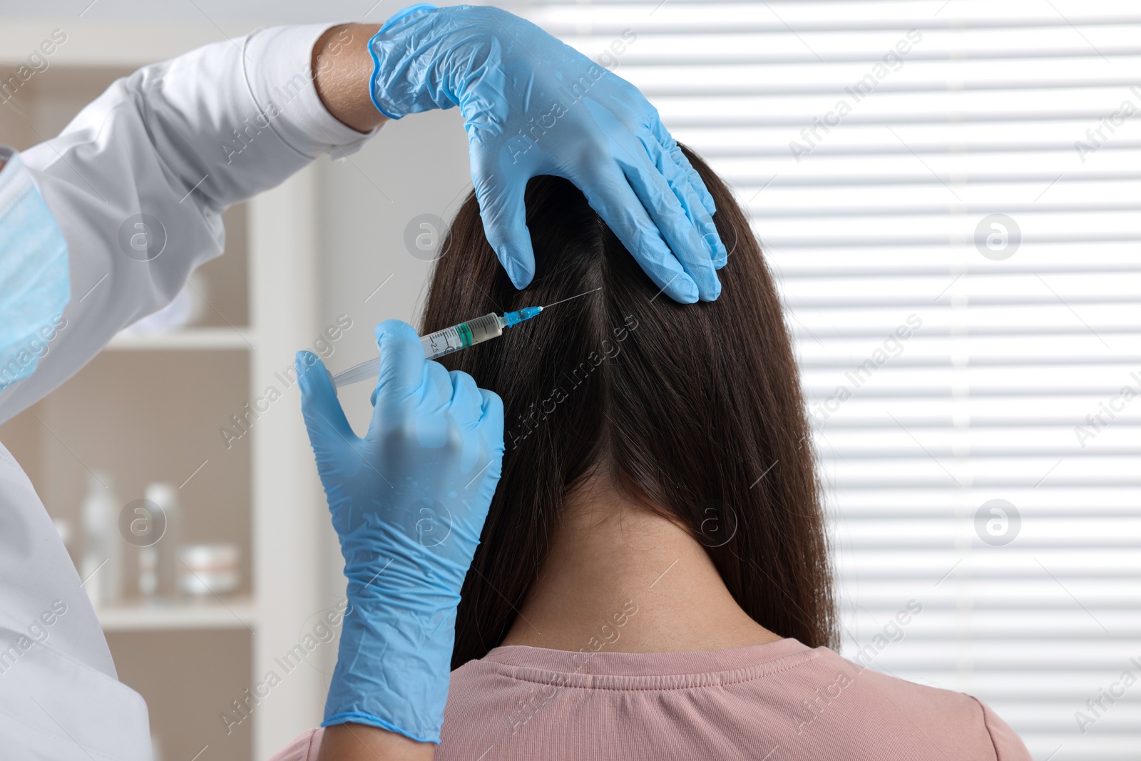 Photo of Trichologist giving injection to patient in clinic, closeup