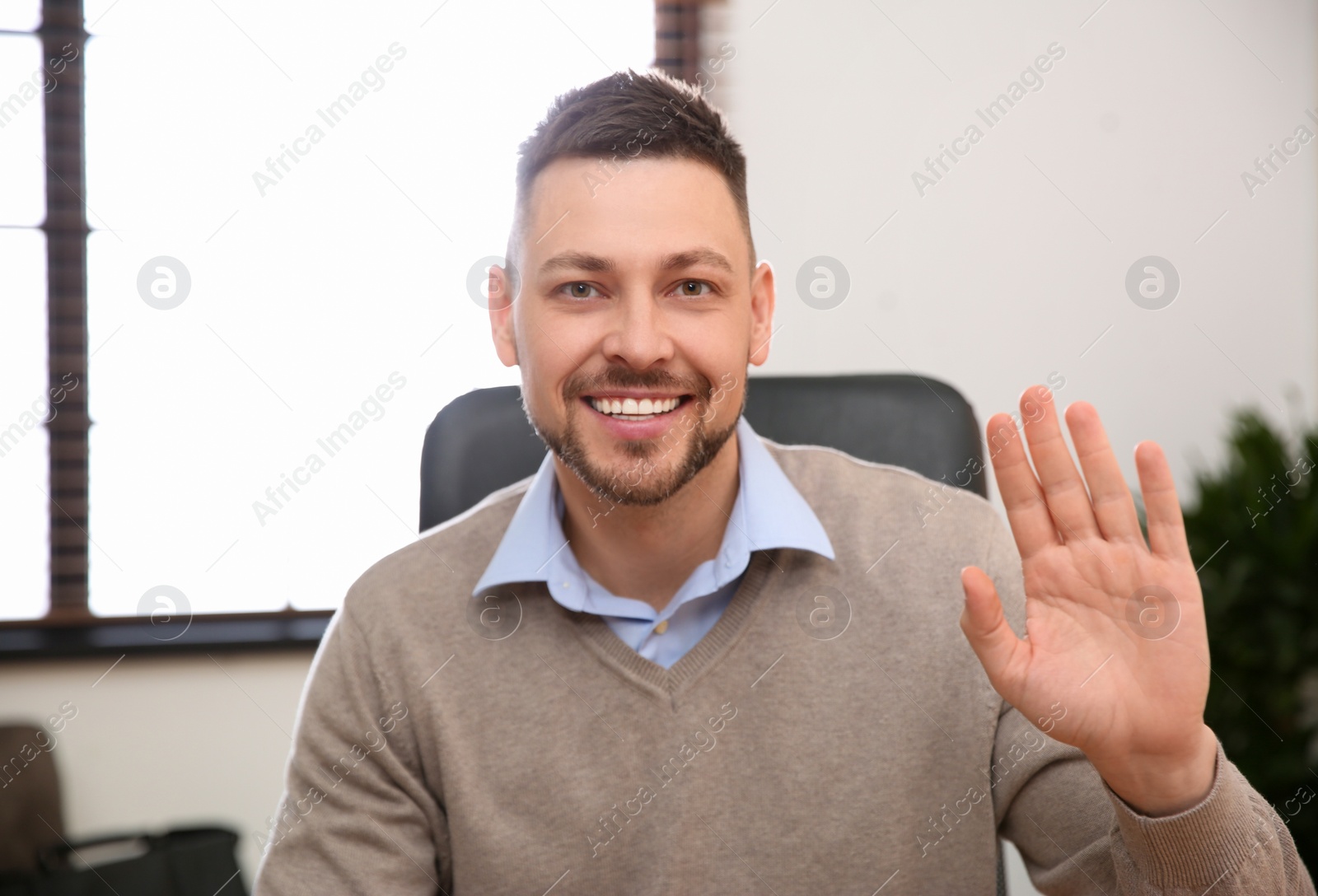 Photo of Man using video chat in office, view from web camera