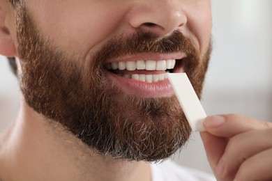 Man with chewing gum on blurred background, closeup