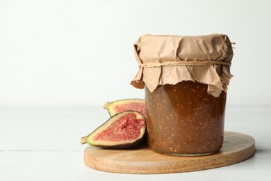 Photo of Homemade delicious fig jam on white wooden table