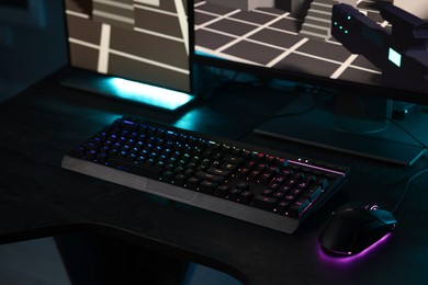 Playing video games. Computer monitor, keyboard and mouse on table indoors