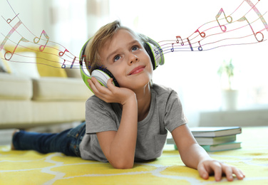 Image of Cute little boy listening to music with headphones at home. Bright notes illustration