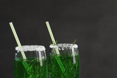 Photo of Glasses of homemade refreshing tarragon drink on black background