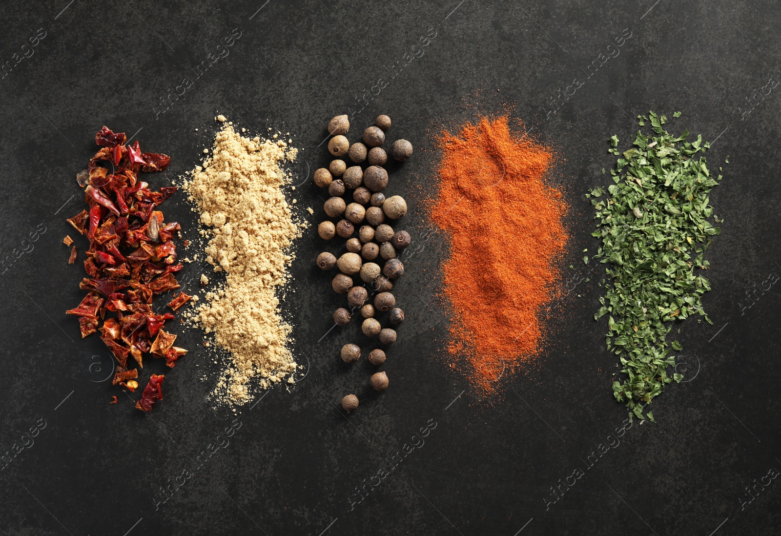 Photo of Many different spices on black table, flat lay