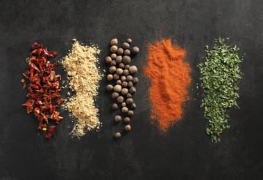 Photo of Many different spices on black table, flat lay