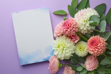 Photo of Blank invitation card and beautiful flowers on violet background, flat lay. Space for text