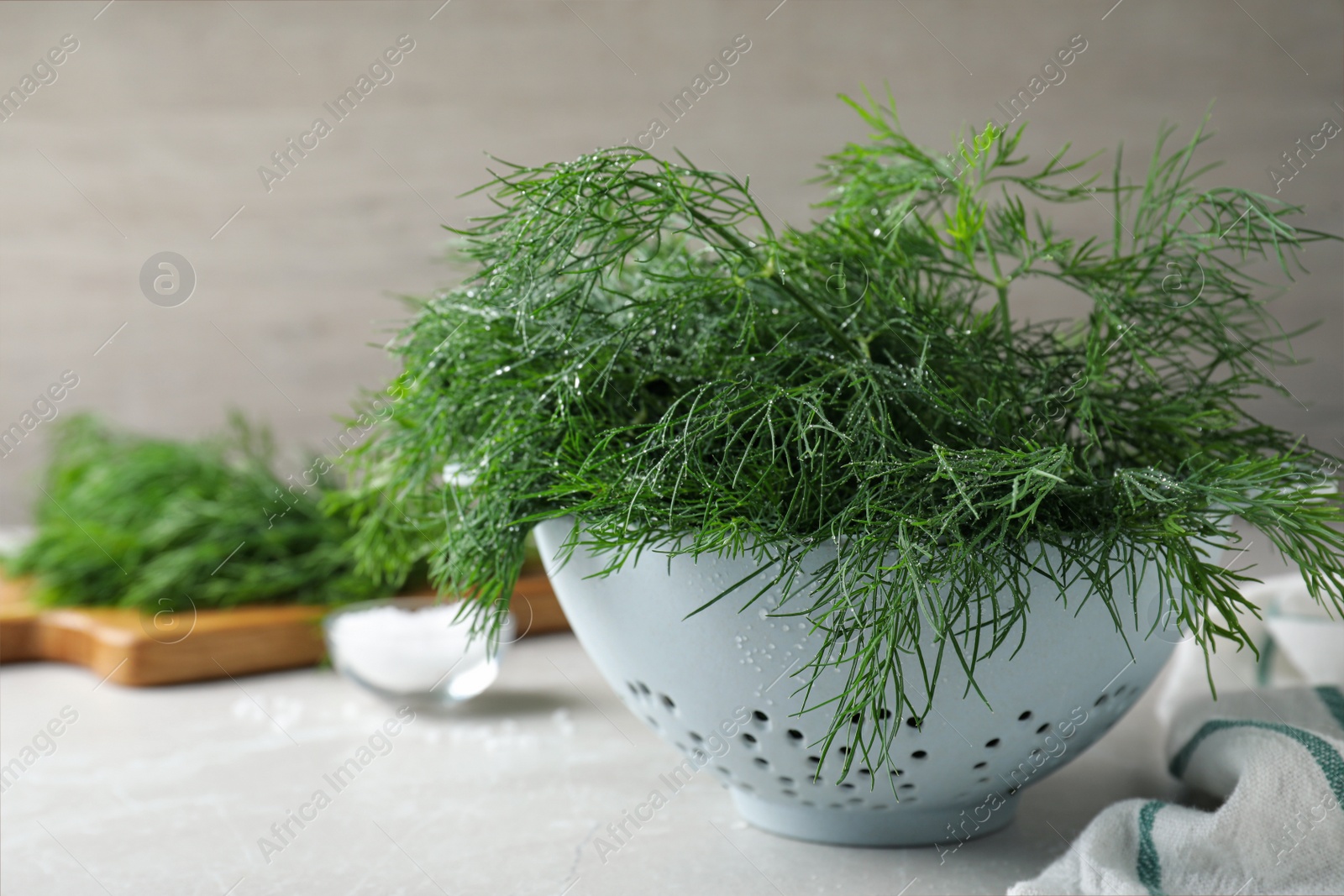 Photo of Fresh dill in colander on white table