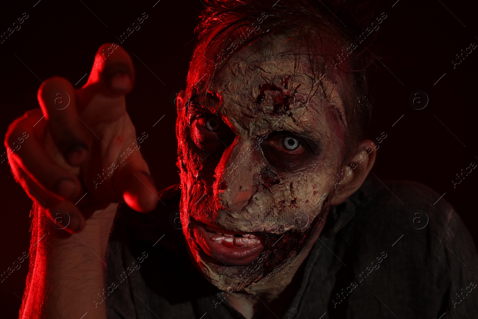 Photo of Scary zombie on dark background, closeup. Halloween monster