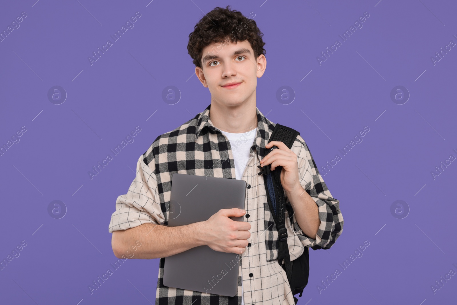 Photo of Portrait of student with backpack and laptop on purple background