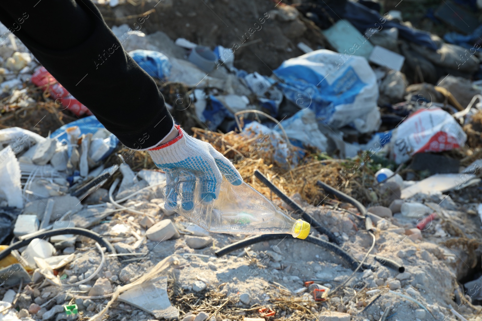 Photo of Woman picking up plastic garbage outdoors, closeup