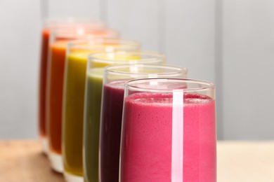 Many different tasty smoothies against white background, closeup