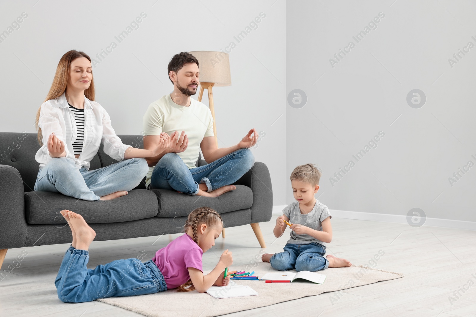 Photo of Parents meditating while their children painting at home
