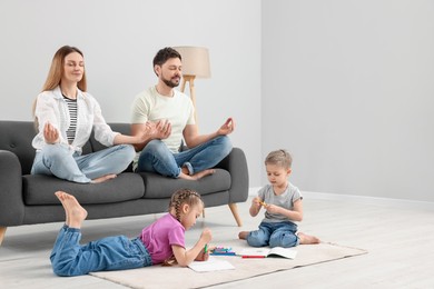 Parents meditating while their children painting at home