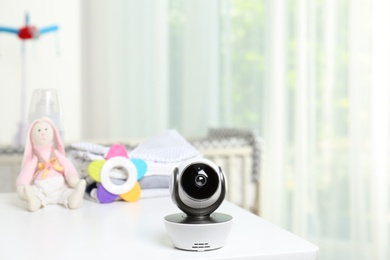 Photo of Baby camera and accessories on table in room. Video nanny