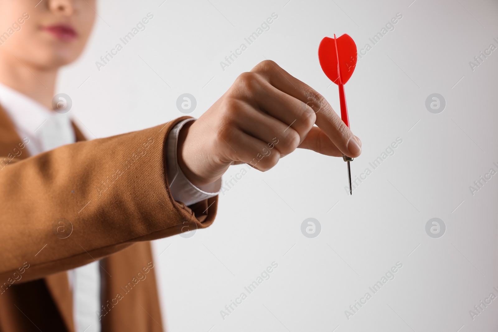 Photo of Businesswoman holding red dart on white background, closeup