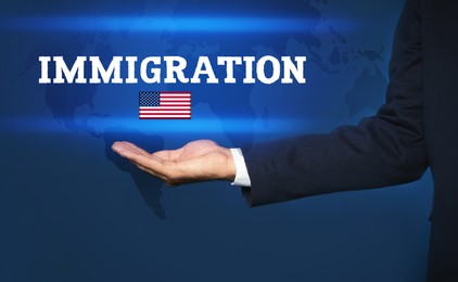 Image of Immigration. Businessman with word and flag of America on dark blue background, closeup