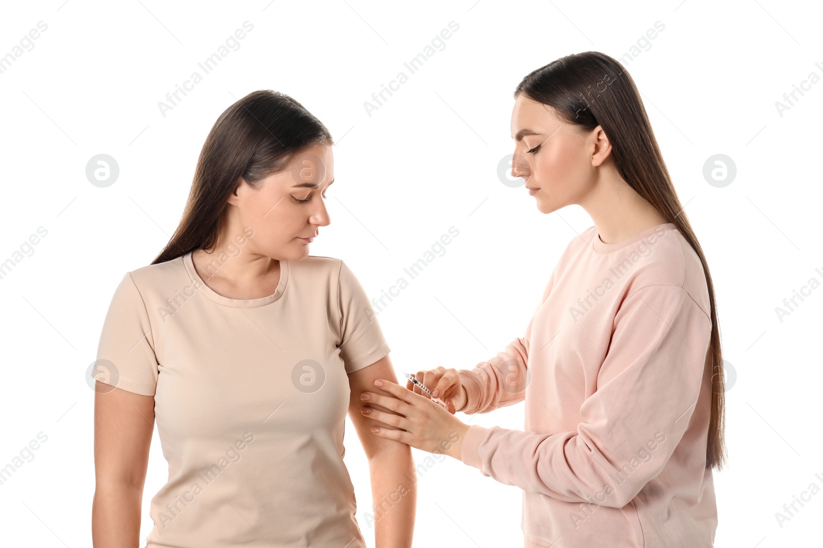 Photo of Woman giving insulin injection to her diabetic friend on white background