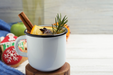 Aromatic white mulled wine in mug on table