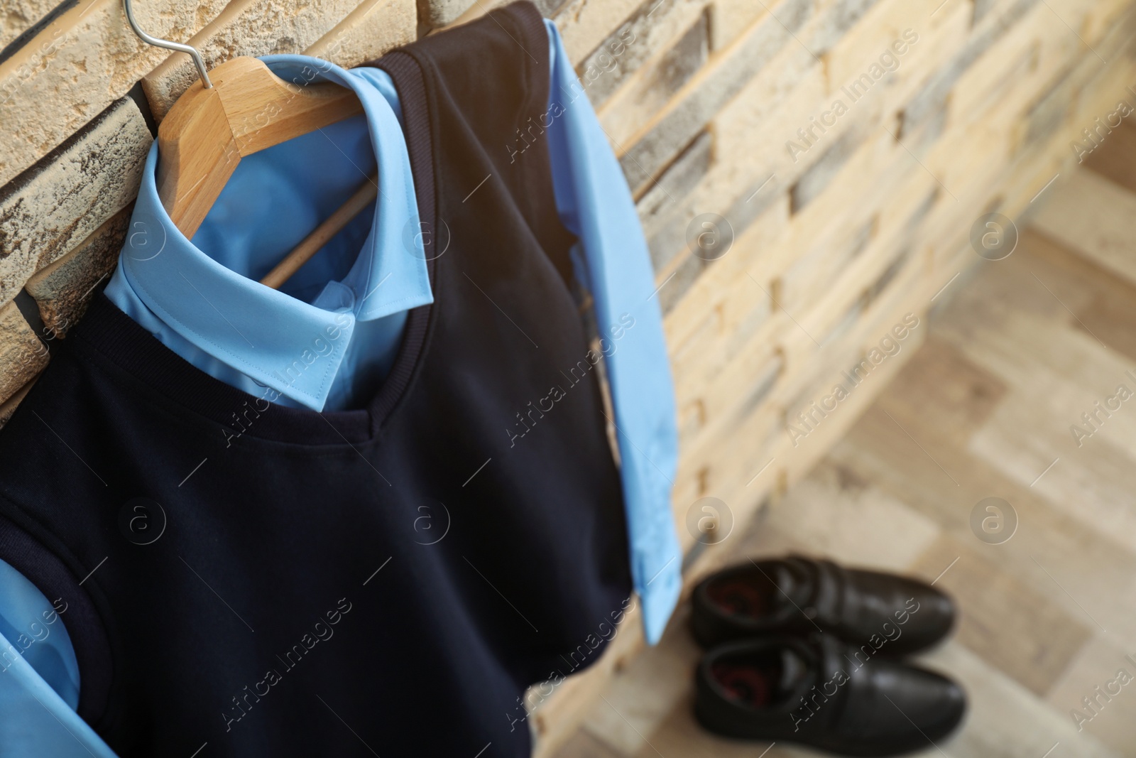 Photo of School uniform for boy hanging on brick wall