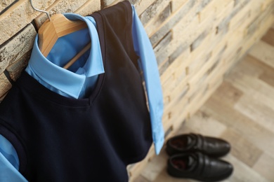 Photo of School uniform for boy hanging on brick wall