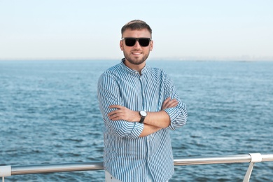 Photo of Portrait of handsome young man on sea pier