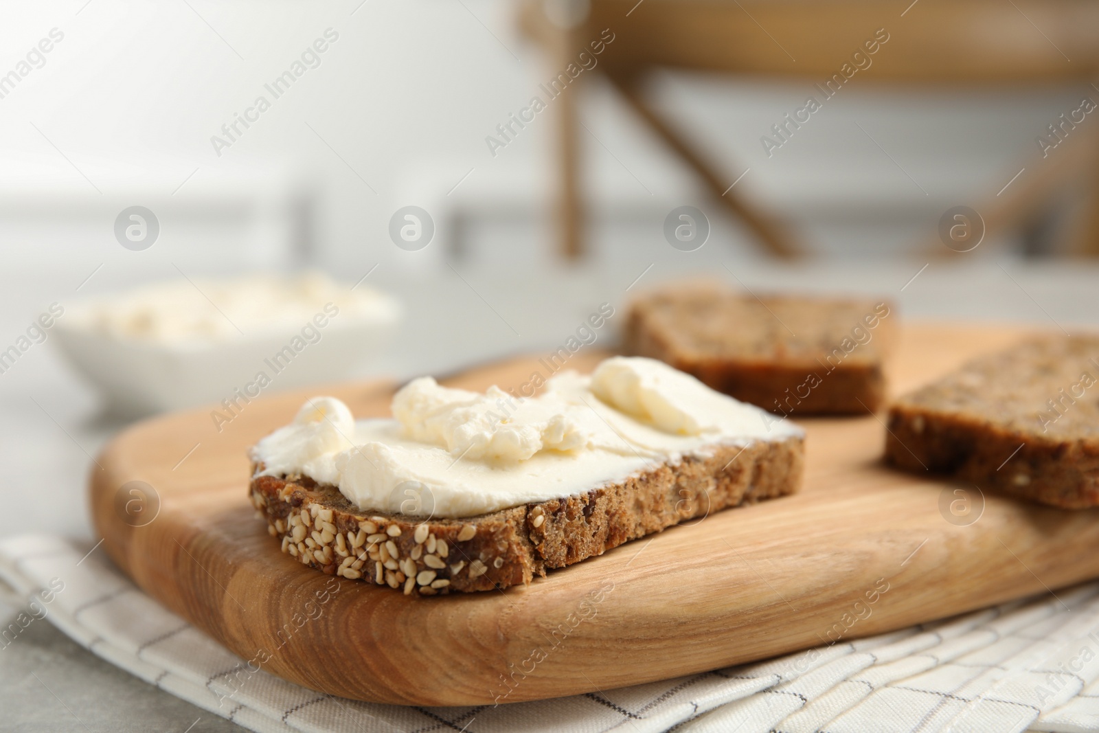 Photo of Bread with cream cheese on wooden table, closeup