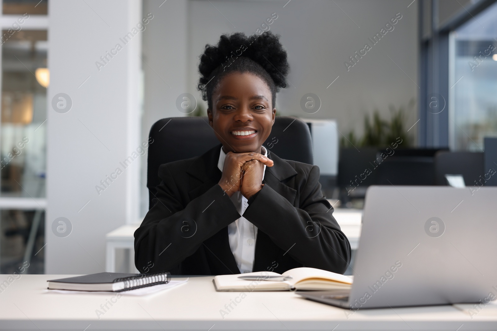 Photo of Happy woman working at table in office. Lawyer, businesswoman, accountant or manager