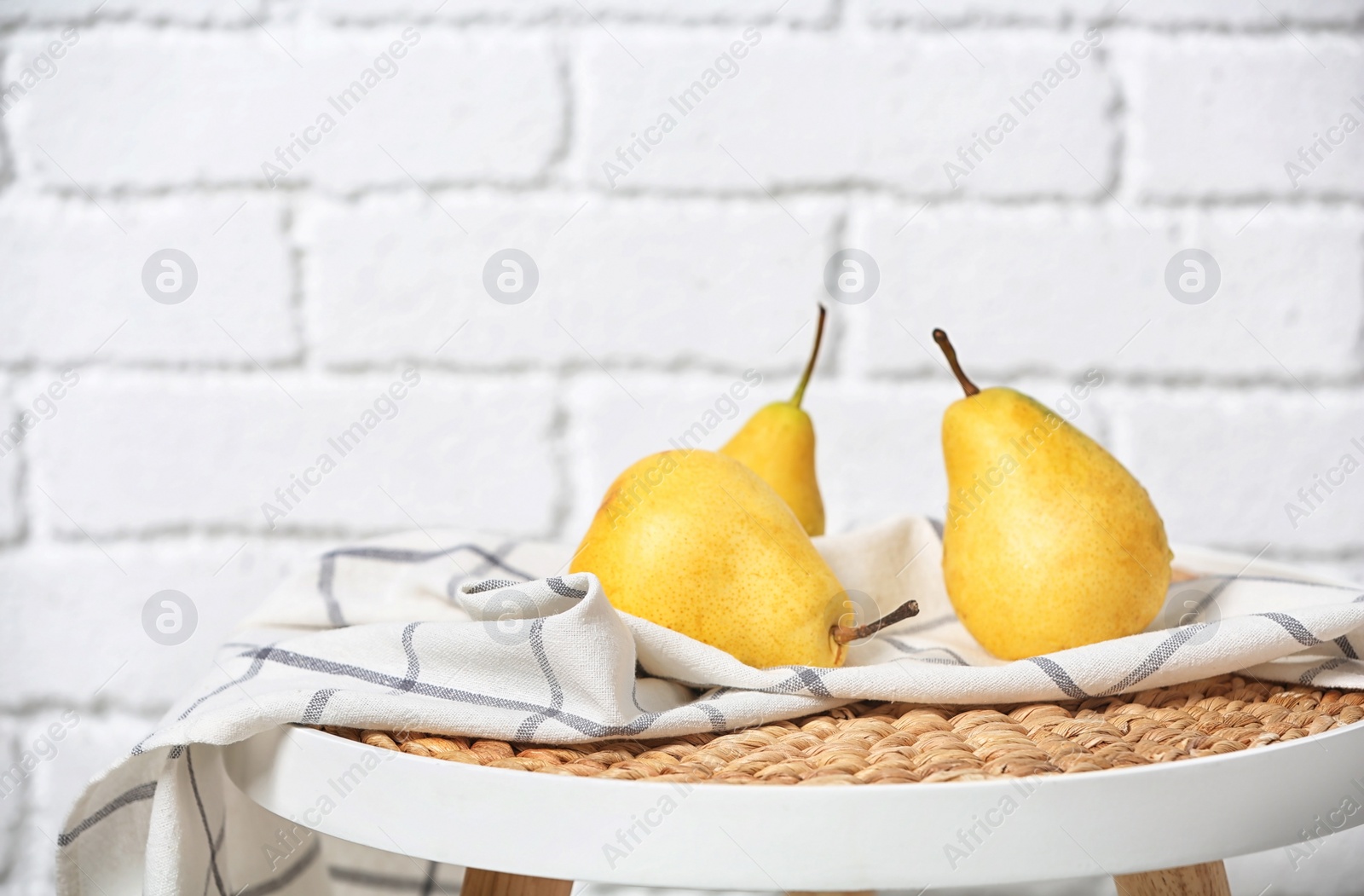 Photo of Ripe pears on table near brick wall