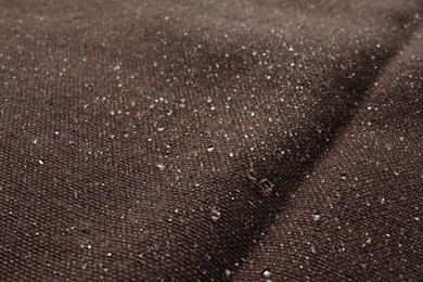 Photo of Texture of brown fabric with water drops as background, closeup