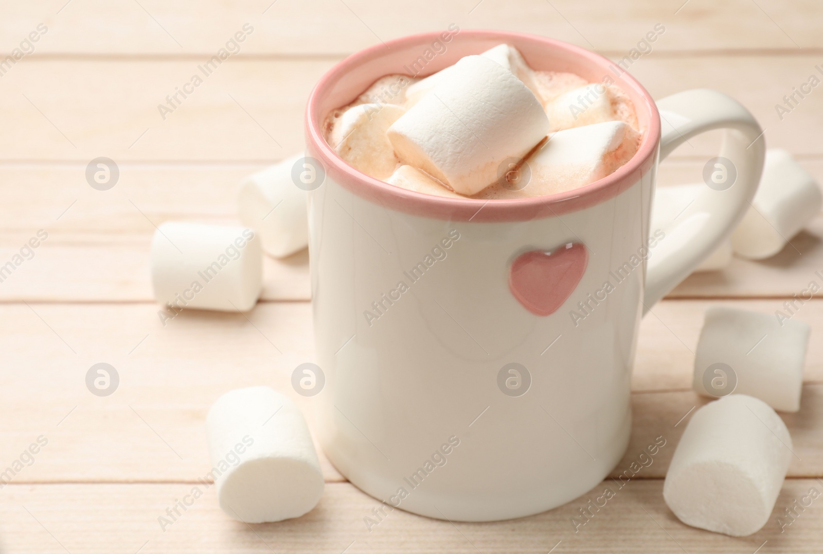 Photo of Tasty hot chocolate with marshmallows on light wooden table, closeup