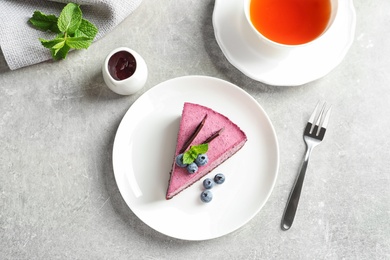 Photo of Flat lay composition with piece of tasty blueberry cake on gray table