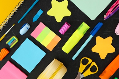 Photo of Flat lay composition with different school stationery on blackboard. Back to school