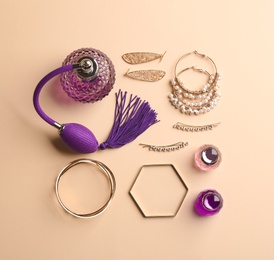 Photo of Composition with perfume bottles and jewellery on color background, flat lay