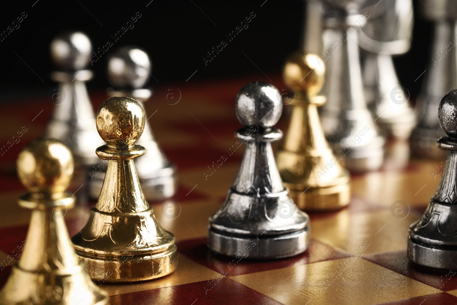 Photo of Chessboard with game pieces on black background, closeup