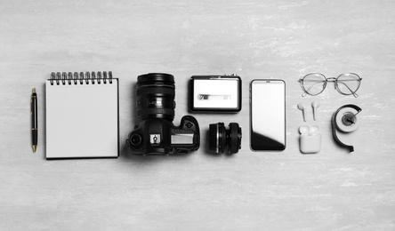 Photo of Flat lay composition with equipment for journalist on light table