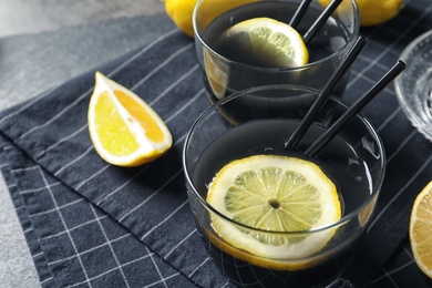 Photo of Glasses with natural black lemonade on table, closeup